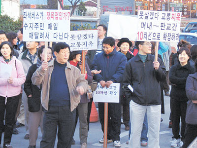 수지시민연대 소속 주민 200여명이 23일 경기 용인시 수지읍 동천리 머내사거리 앞에서 ‘교통체증 해소 및 특정업체 노선 독점 철폐’를 요구하며 시위를 벌이고 있다.사진제공 수지시민연대