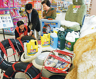 롯데마트 서울 영등포점에 마련된 자동차 월동용품 코너에서 한 고객이 스노 타이어에 대한 설명을 듣고 있다. - 동아일보 자료사진