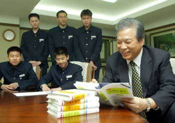 상산고 재학생들에게 줄 ‘정석’ 표지 안쪽에 사인을 하는 홍성대 이사장./전주〓신석교기자