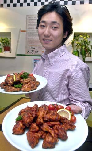 서울 신촌의 한 닭고기음식점에서 ‘닭사모’ 회장 이두호씨가 닭고기 요리를 들어보이며 즐거워하고 있다. 이종승기자 urisesang@donga.com