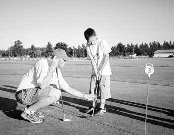 해외 영어 캠프에 참가한 한 초등학생이 현지인 강사에게 골프 강습을 받고 있다.