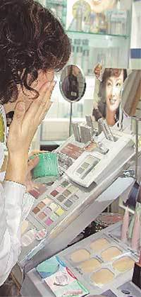 한 여성이 기능성 화장품을 구입하기 위해 샘플을 얼굴 부위에 바르고 있다. /동아일보 자료사진