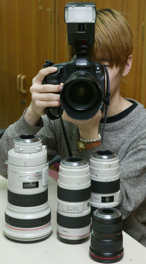 렌즈를 필요에 따라 바꿔 쓸 수 있는 디지털 SLR 카메라가 마니아들에게 인기를 끌고 있다. 한 사용자가 교환식 렌즈를 연결한 디지털 SLR 카메라를 조작하고 있다.강병기기자