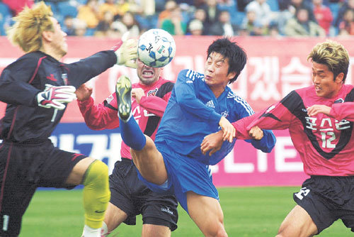 FA컵 축구 결승전에서 삼성 김두현(오른쪽에서 두번째)이 포항 수비수들의 집중적인 마크를 뚫고 오른발로 볼을 먼저 따내기 위해 안간힘을 쓰고 있다. 이를 막기 위해 달려나간 포항 골키퍼는 김병지(왼쪽).제주연합