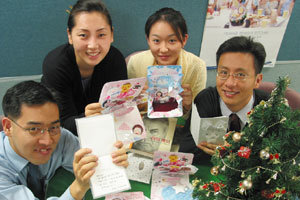 삼성카드 직원들이 전국의 소년소녀 가장에게 보내기 위해 만든 크리스마스 카드를 들어보이고 있다.