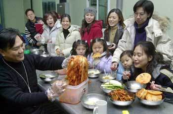 인터넷 경매사이트 옥션의 김치커뮤니티 회원들이 14일 전북 무주에서 모여 김치파티를 열고있다. 먹기 좋게 익은 배추김치를 들어보이는 사람이 ‘산.들. 바람님이 올리는 김치’를 만들어 인터넷 경매에 부치는 김치상인 이광득씨(왼쪽 끝)다./무주〓신석교기자