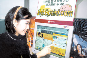 카드사 홈페이지에는 각종 생활정보가 가득하다. 한 여성 네티즌이 LG카드 홈페이지에서 ’돈되는 정보’를 가리키며 활짝 웃고 있다.사진제공 LG카드