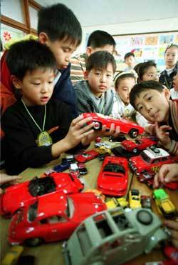 자동차 수집이 취미인 아이들이 자동차를 신기한 듯 살펴보고 있다./동아일보 자료사진