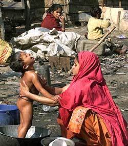 아이를 물로 씻기는 방글라데시 여인. 그녀가 머리에 쓰고 있는 옷 ‘사리’를 필터로 사용해 콜레라를 막을 수 있다는 사실이 밝혀졌다. -동아일보 자료사진