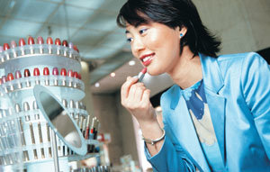일본 헬레나 루빈스타인의 아키고 다카기씨가 도쿄 신주쿠 세이부 백화점에서 초봄 메이크업에 어울리는 립스틱을 고르고 있다. 현재 일본에서는 살짝 오렌지색이 섞인 베이지색 립스틱이 잘 팔린다.