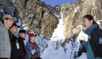금강산 육로 시범관광 이후 금강산관광특구의 분위기가 전보다 부드러워지고 있다. 얼어붙은 구룡연 폭포 앞에서 북측 안내원의 설명을 듣고 있는 관광객들. -금강산=박영대기자