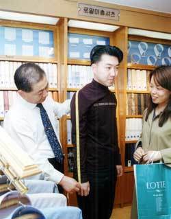 롯데백화점 서울 본점에 입점해 있는 맞춤 와이셔츠 전문매장인 ‘로얄맞춤셔츠’에서 한 고객이 치수를 재고 있다. 와이셔츠 가격은  9만∼30만원. 동아일보 자료사진