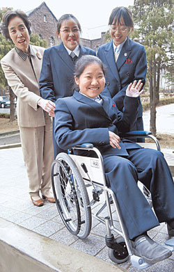 전교생 중 단 한 명뿐인 장애 학생을 위해 학교 계단을 개보수한 서울 숙명여고에서 7일 이 학교 1학년 문화진양(16)이 휠체어를 타고 웃으며 친구들과 함께 건물 안으로 들어가고 있다. 이훈구기자