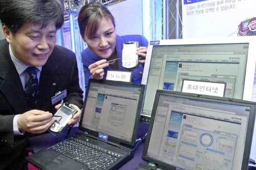 ‘어떤 게 더 빠를까.’ KT 직원들이 13일 서울 종로구 세종로 사옥에서 2.3GHz 휴대 인터넷을 선보인 뒤 휴대 인터넷과 기존 무선랜의 속도를 비교해 보이고 있다. 안철민기자