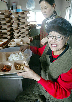 서울지하철 신도림역에서 무료급식소를 운영하는 이막래 할머니가 14일 노인과 노숙자들에게 나눠줄 음식을 담고 있다. -원대연기자