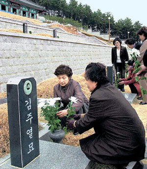 3·15의거 기념일을 하루 앞둔 14일 경남 마산시 구암동 애기봉에 조성된 ‘국립 3·15 묘지’에서 한국부인회 마산시 회원들이 의거 당시 목숨을 잃은 김주열 열사의 가묘에 헌화하고 있다. -마산=최재호기자