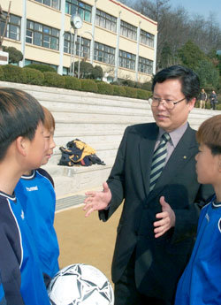 외환은행 김장민 김포지점장이 13일 경기 김포시 대곶초등학교에 후원금을 전달한 뒤 축구부 선수들과 얘기를 나누고 있다. -김포=황금천기자