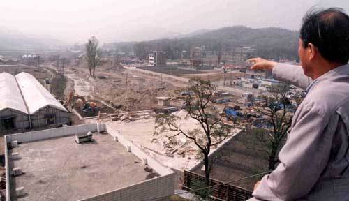 경기 판교신도시에 아파트와 단독주택 등 모두 2만9700가구가 지어질 전망이다. 한 성남시민이 판교신도시가 들어서는 부지를 가리키고 있다. 동아일보 자료사진