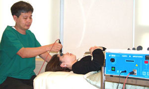 안과 질환 : 안과 의사가 눈이 충혈된 환자에게 고주파를 이용해 눈 주위에 마사지를 해주고 있다.