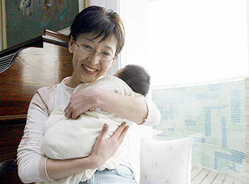 ‘초보 엄마’ 윤석화씨가 입양한 아들을 안고 행복한 미소를 짓고 있다. 박주일기자
