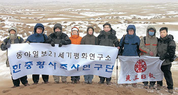 한중 황사 조사단이 황사 발원지인 중국 서부 텅거리 사막을 답사한 뒤 21세기평화연구소 플래카드와 동아일보 사기를 들고 기념 촬영하고 있다. -중국 텅거리사막=전영한기자