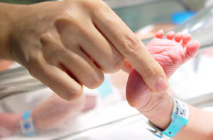 서울 삼성제일병원의 신생아 중환자실에서 의료진이 33주 된 조산아의 발을 들며 아기의 반응을 살펴보고 있다.