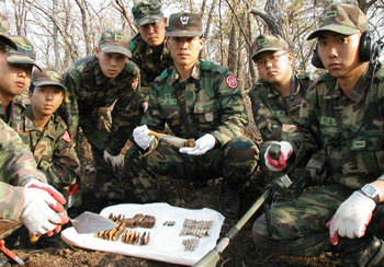 경주시 안강읍 금곡산 정상에서 육군 50사단 금병학 대위와 병사들이 M-1 실탄과 탄피 등 전사자들의 유품을 정리하고 있다. 경주=이권효기자 boriam@donga.com