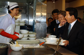 '아니, 각하…'　2003년 3월24일 낮 노무현 대통령이 청와대 구내식당에서　점심식사를 하기 위해 콩나물밥을 담던 중 음식이 떨어지　자 손으로 집어 먹고 있다.