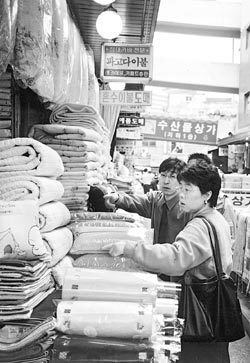 서울 남대문시장 내 대도상가 1층 침구매장에서 양복을 입은 직원이 한 여성 고객에게 여름용 이불에 대해 설명하고 있다.박 용기자