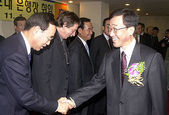 2001년 11월 1일 통합 국민은행장이 된 김정태(오른쪽)씨가 명동 본점에서 열린 취임식을 마친 뒤 임원들과 악수하고 있다. -동아일보 자료사진