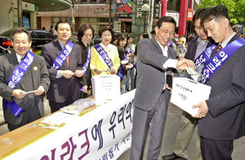 동아일보와 35개 시민단체가 공동으로 참여하는 이라크 난민돕기 시민네트워크가 28일 서울 중구 명동 우리은행 앞에서 성금 모금을 위해 배지를 팔고 있다. -권주훈기자