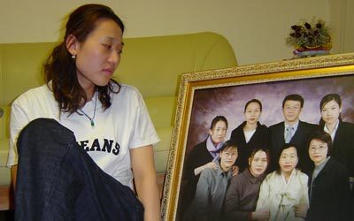 이남수가 실종된 어머니 김환순씨와 1남6녀가 함께 찍은 가족사진을 바라보며 눈시울을 붉히고 있다. 안영식기자 ysahn@donga.com