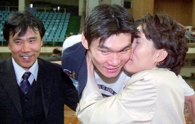 지난달 13일 TG엑써스가 프로농구 우승을 차지한 직후 아들의 모든 경기를 지켜보며 소리없이 응원해 온 김주성의 어머니 이영순씨(오른쪽)가 아들의 얼굴에 입을 맞추고 있다. 왼쪽은 아버지 김덕환씨. 사진제공=한국농구연맹(KBL)