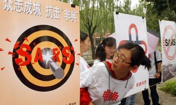 14일 중국 베이징의 칭화대에서 한 학생이 사스(SARS·중증급성호흡기증후군) 퇴치를 주제로 한 작품전시회에 출품된 포스터를 살펴보고 있다. -난닝=신화 연합