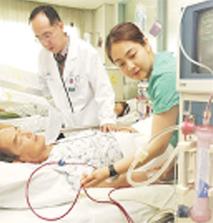 울산대 서울아산병원 인공신장실에서 이 병원 신장내과 김순배 교수(왼쪽)와 간호사가 혈액투석을 받고 있는 환자의 상태를 점검하고 있다.전영한기자 scoopjyh@donga.com