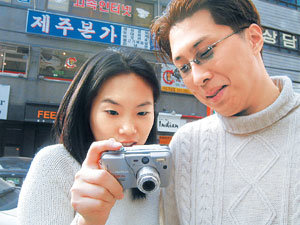 최근 디지털카메라는 찍은 사진을 액정화면을 통해 바로 확인할 수 있어 편리하다. 사용자들이 디지털카메라에 저장된 사진을 살펴보고 있다.동아일보 자료사진
