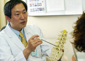 윤도흠 교수가 척추 디스크 환자에게 등뼈의 모형을 보여주며 진단 결과를 설명하고 있다.원대연기자 yeon72@donga.com