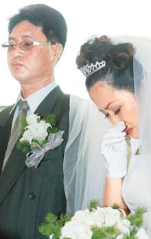 암으로 시한부 인생을 살고 있는 한국인 최충렬씨(왼쪽)와 결혼식을 올리던 중국동포 오춘화씨가 예식 도중 울먹이고 있다.변영욱기자