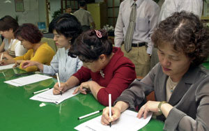 서울 신답초등학교 교사들이 29일 오후 학교 교무실에서 한국교원단체총연합회가 벌이고 있는 윤덕홍 교육부총리의 퇴진 서명 운동에 동조해 서명을 하고 있다.-이종승기자