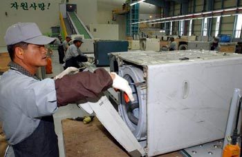 30일 문을 연 국내 최대 전자제품 재생센터인 경기 용인시 ‘수도권 전자제품 리사이클링센터’에서 근로자들이 버려진 세탁기 등을 손보고 있다. 용인=연합
