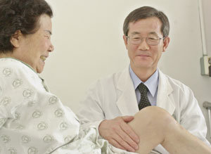 배대경 교수가 무릎 수술을 받은 환자의 무릎을 만지며 수술 결과를 살피고 있다. 권주훈기자 kjh@donga.com