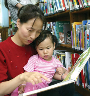 아이들이 독서 습관을 갖도록 하기 위해서는 어려서부터 부모가 먼저 책을 읽는 모습을 보여주는 것이 가장 중요하다. 서울 종로구 사직동 어린이도서관에서 한 어머니가 자녀와 책을 고르고 있다. 이훈구기자 ufo@donga.com