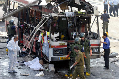 이스라엘 경찰이 11일 예루살렘 중심가에서 발생한 자살폭탄 테러 사건 현장을 조사하고 있다. 만신창이가 된 버스 주변에 미처 다 수습하지 못한 희생자 유해가 널려 있다.[AFP]