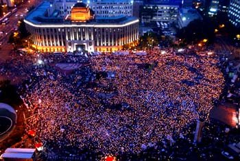 13일 저녁 서울시청 앞 광장에서 열린 여중생 사망사건 1주기 추모 행사에 모인 시민들이 촛불을 들고 효순 미선양을 추모하고 있다. [연합]