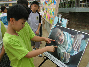 서울 방이초등학교 학생들이 ‘사랑의 기아체험 걷기대회’의 일환으로 교내에 전시된 이라크 어린이 사진을 보고 있다.-사진제공 유니세프