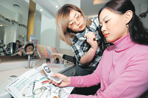 한 여성 고객이 KTF의 '핫코드' 서비스를 이용해 잡지에 실린 상품 정보를 얻고 있다. 사진제공 KTF