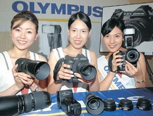 24일 서울 중구 소공동 조선호텔에서 열린 렌즈교환식 디지털 카메라(올림푸스 E-1) 발표회에서 모델들이 신제품을 들어 보이고 있다. 이 카메라는 렌즈 크기와 무게를 일반렌즈의 절반으로 줄인 것이 특징이다. 박영대 기자