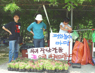 서울 경기 지역 6개 어린이집 어린이들과 학부모들이 고양시의 한 문화공원에서 이라크 어린이 돕기 성금 마련을 위한 바자회와 함께 무기 장난감을 꽃모종으로 바꿔주는 행사를 열고 있다.-사진제공 시민네트워크