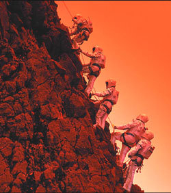 탐사단원들이 아프리카 레위니옹섬에서 우주복을 입고 산을 오르고 있다.-동아사이언스 자료사진
