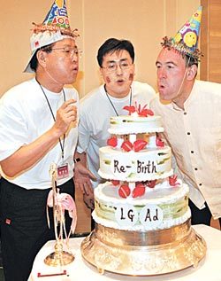 LG애드 이인호 사장(왼쪽)과 오길비 앤 매더 아시아 퍼시픽의 마일즈 영 회장(오른쪽)이 새로 태어난다는 의미로 마련한 케이크의 촛불을 끄고 있다. 사진제공 LG애드